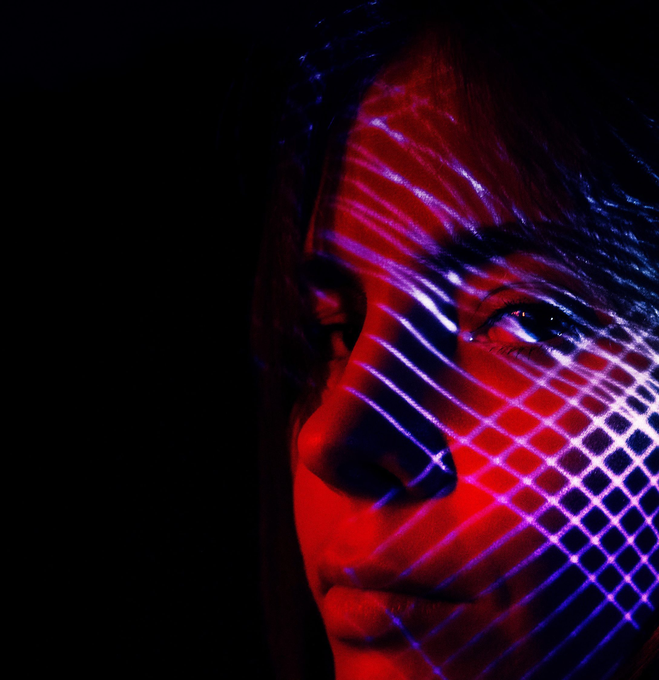 Close up with geometric lights reflected on person's face